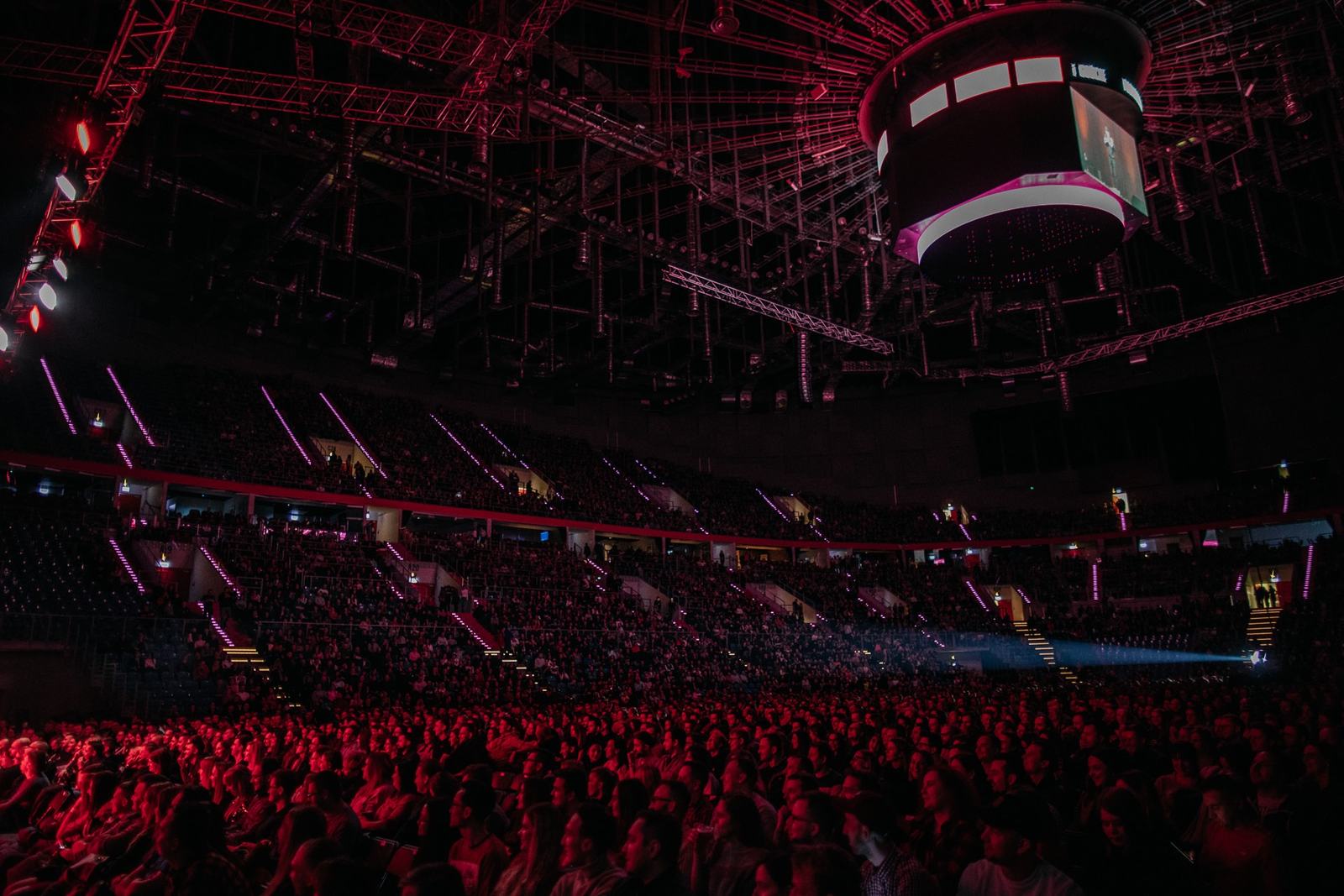 Wypełniona hala widowiskowa w czerwonym świetle podczas show